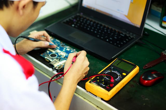 Técnico em eletrônica realizando reparo em placa de circuito com ferramentas profissionais no curso de eletrônica.
