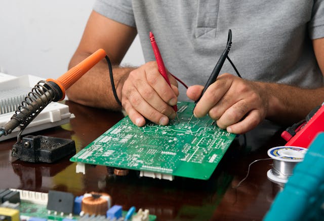 Professor ensinando técnicas de eletrônica em curso de eletrônica  online com suporte aos alunos.